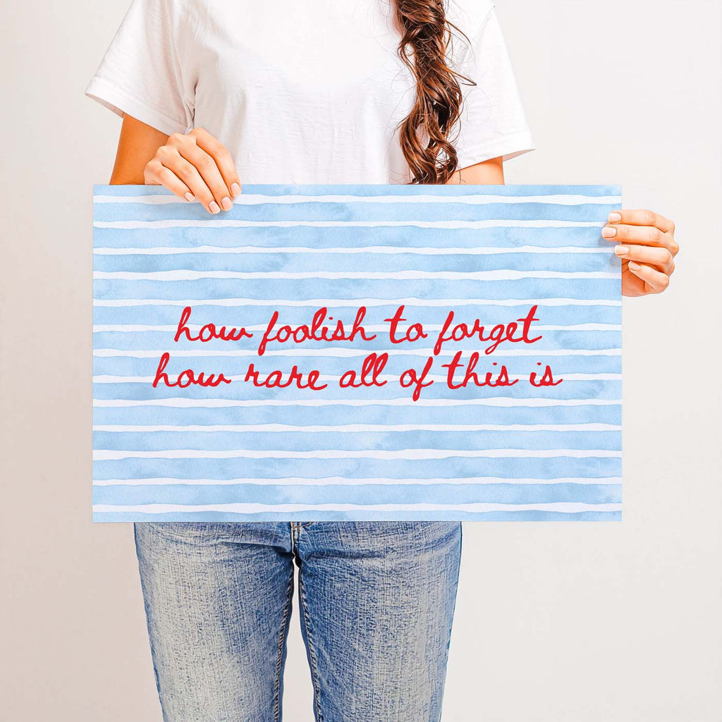 Person holding a sign with motivational quote on a plain background