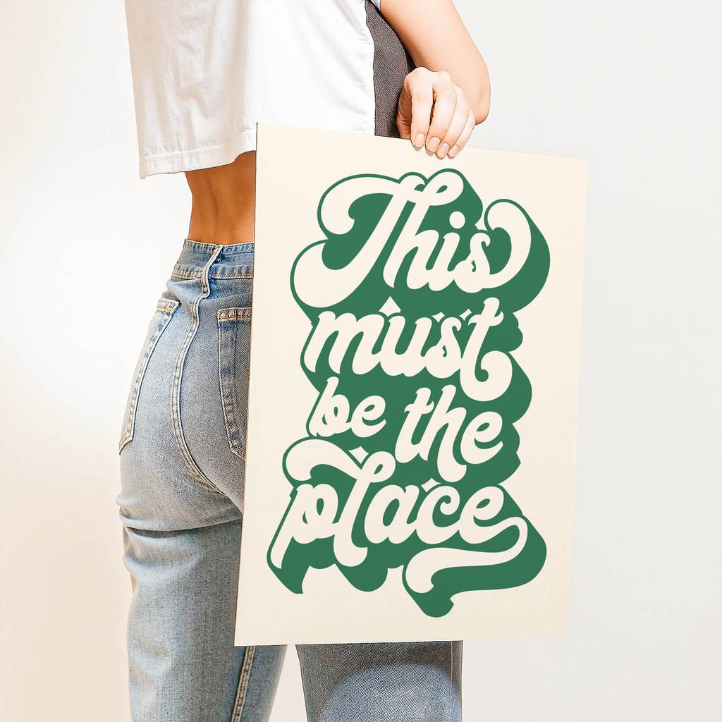 Retro “This Must Be the Place” quote print with vintage-style lettering—warm, welcoming wall art perfect for entryways, living rooms, or studios.